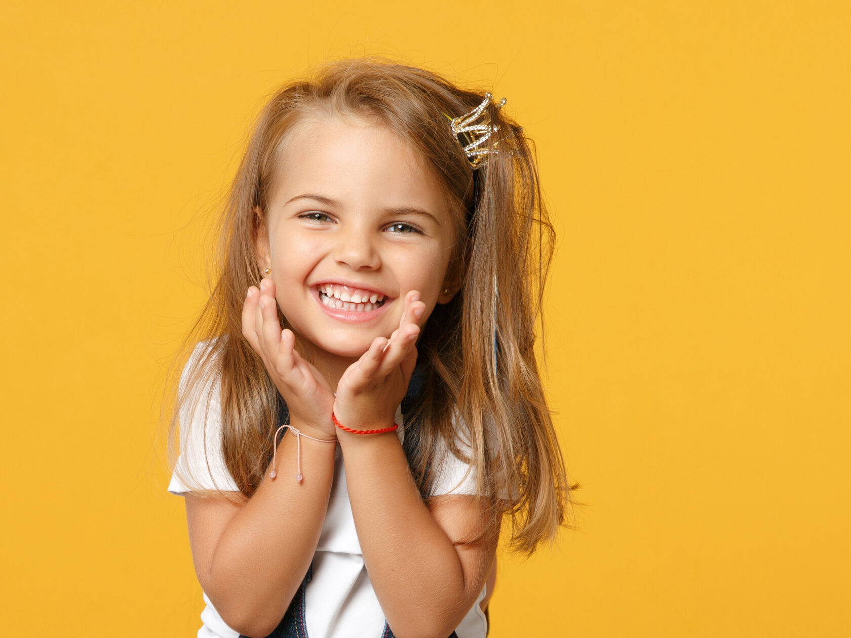 Little cute child kid baby girl 4-5 years old wearing light denim clothes isolated on pastel yellow wall background, children studio portrait.